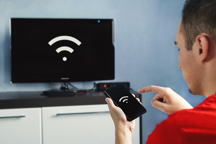 connectivity between smart tv and smart phone through wifi connection. Control your TV with your smartphone. The wifi icon on the phone screen and the monitor